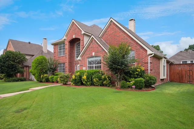 a front view of a house with a garden and plants