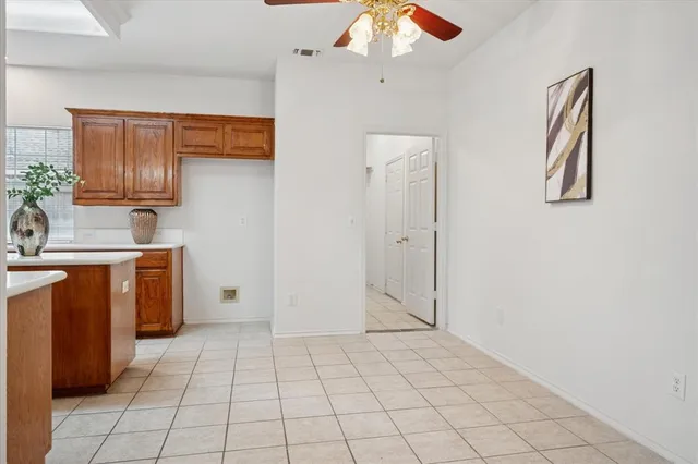 a large kitchen with kitchen island granite countertop a refrigerator a sink a dining table and chairs