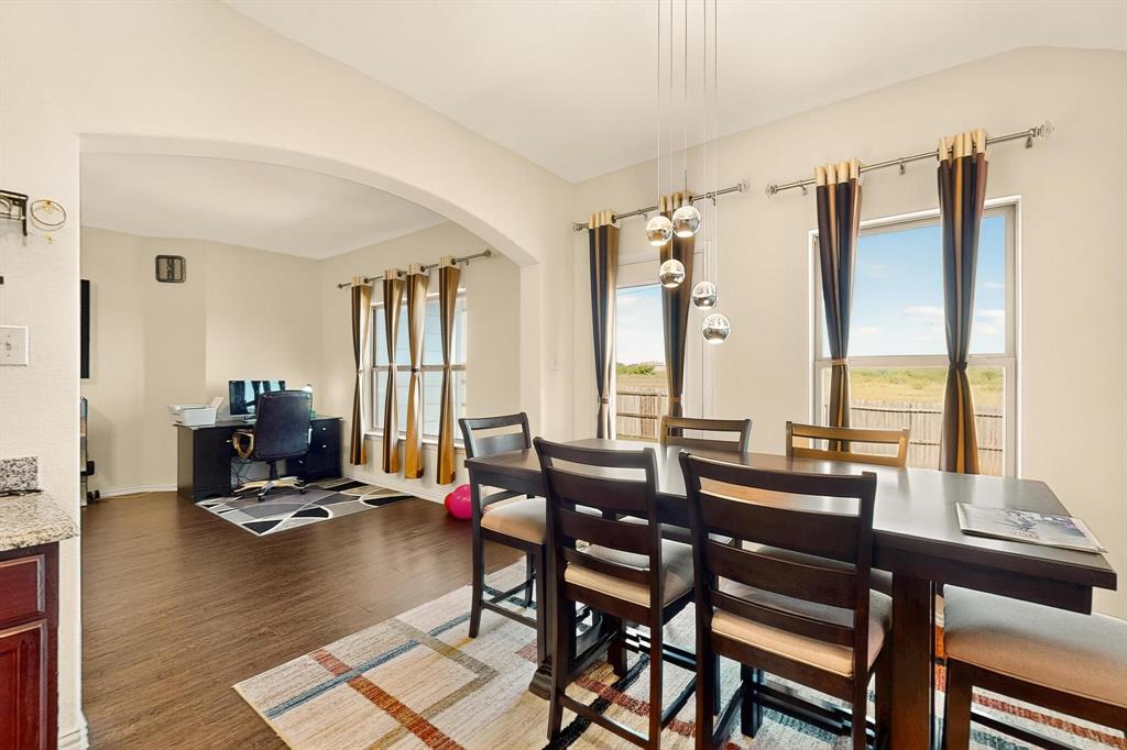 Dining room with an office area, arched walkways, and dark wood finished floors