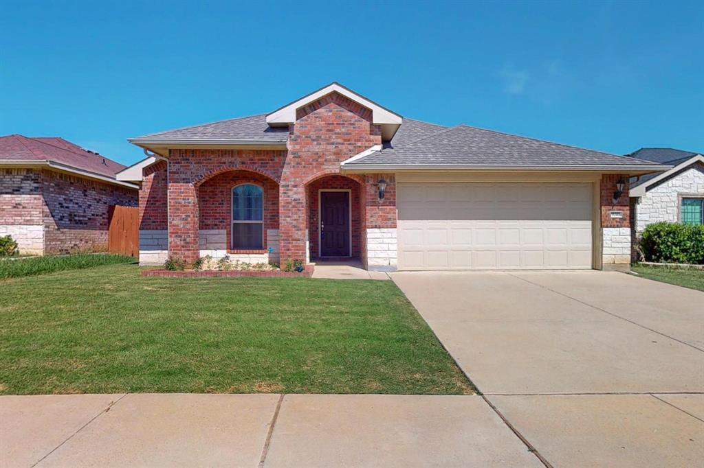 9144 St Barts Road Fort Worth, TX 76123 - Photo 2 of 36 View of front facade with roof with shingles, brick siding, a front yard, a porch, and driveway
