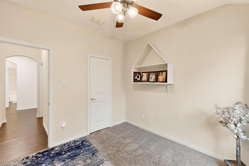 9144 St Barts Road Fort Worth, TX 76123 - Photo 26 of 36 Unfurnished bedroom with arched walkways, ceiling fan, and carpet flooring