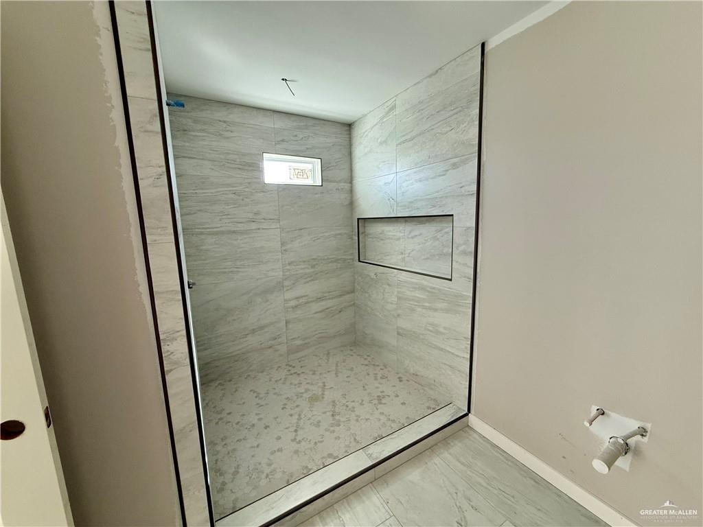 2206 Corales Street Mission, TX 78573 - Photo 12 of 17 a bathroom with a glass shower door