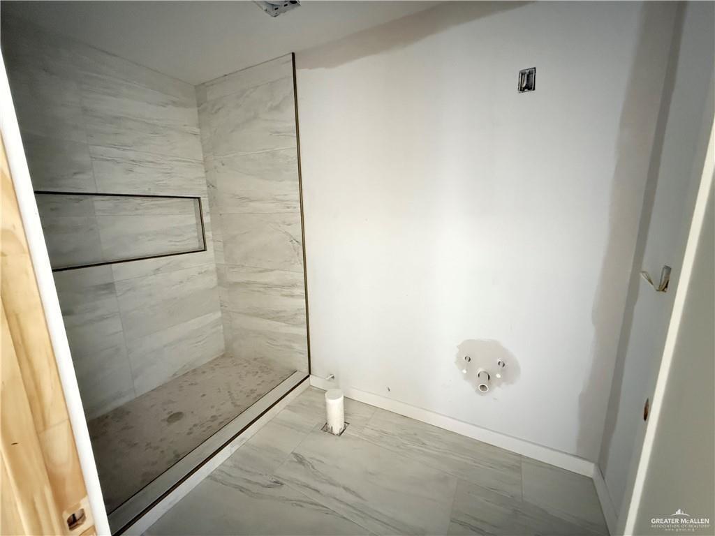 2206 Corales Street Mission, TX 78573 - Photo 16 of 17 a bathroom with a glass shower door