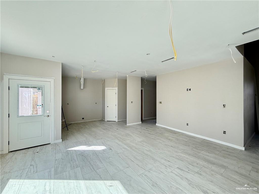 2206 Corales Street Mission, TX 78573 - Photo 5 of 17 an empty room with wooden floor and windows