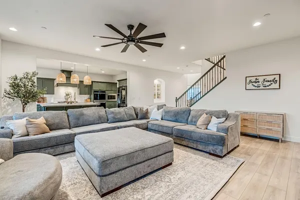 a living room with furniture and a ceiling fan
