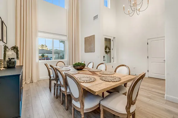 a view of a a dining room with furniture window and wooden floor