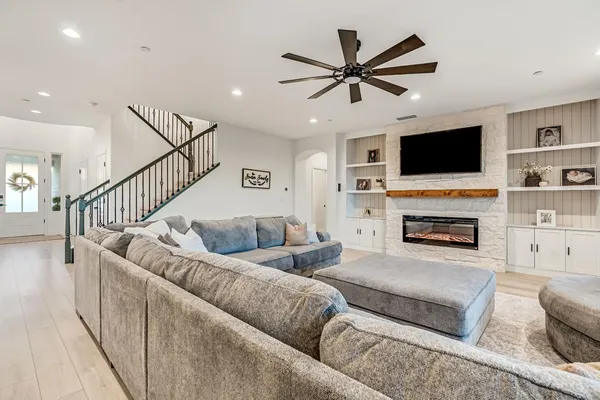 a living room with furniture a flat screen tv and a fireplace