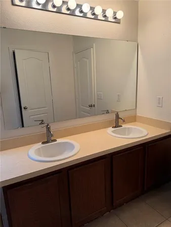 a bathroom with a double vanity sink and a mirror