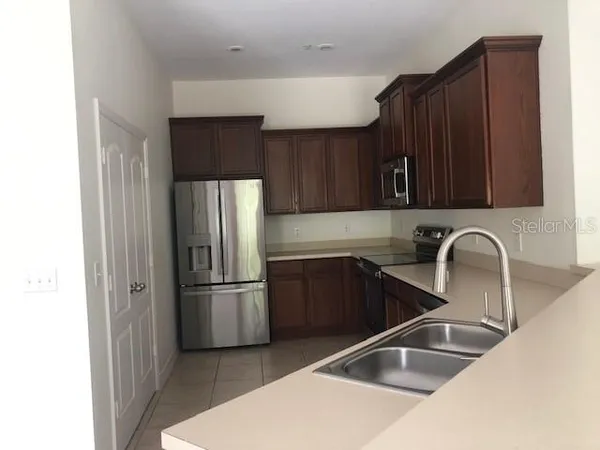 a kitchen with a refrigerator sink and cabinets