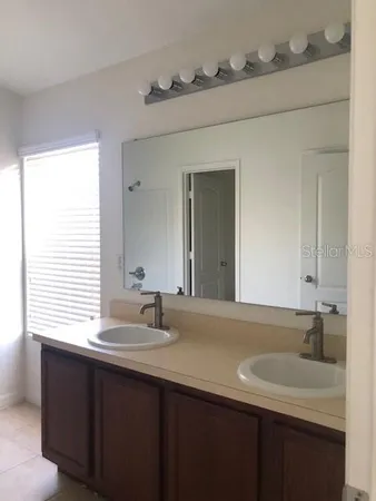 a bathroom with a double vanity sink and a mirror