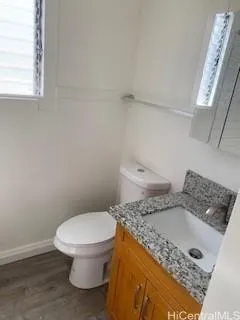 a bathroom with a granite countertop toilet and a sink