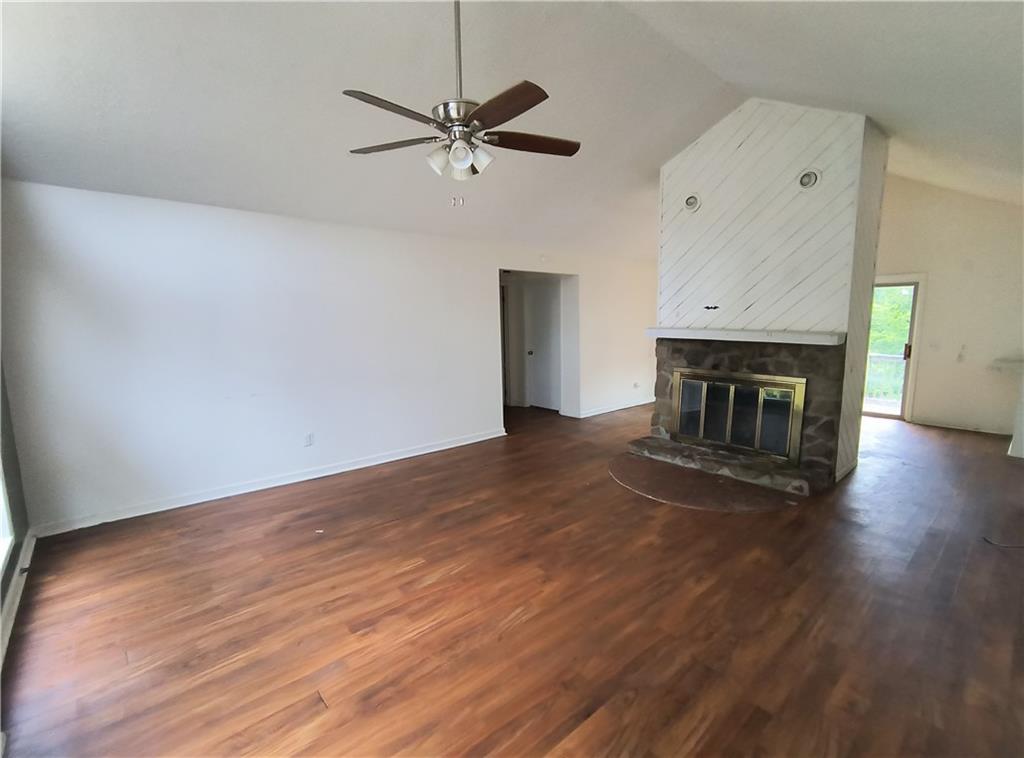 89 Murray Springs Road Chatsworth, GA 30705 - Photo 9 of 14 an empty room with wooden floor fireplace and windows