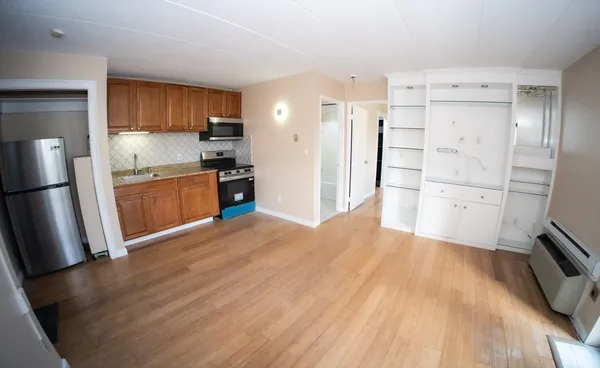 a kitchen with stainless steel appliances a refrigerator sink and wooden floor