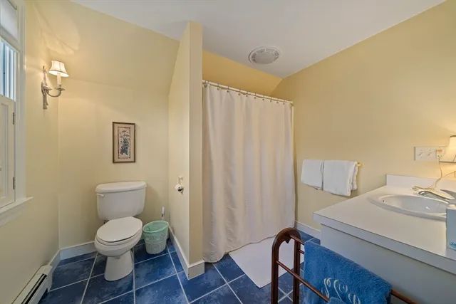 a front view of a house with garden and trees