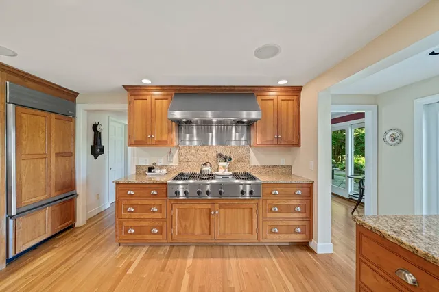 a kitchen with stainless steel appliances granite countertop a sink and a large window