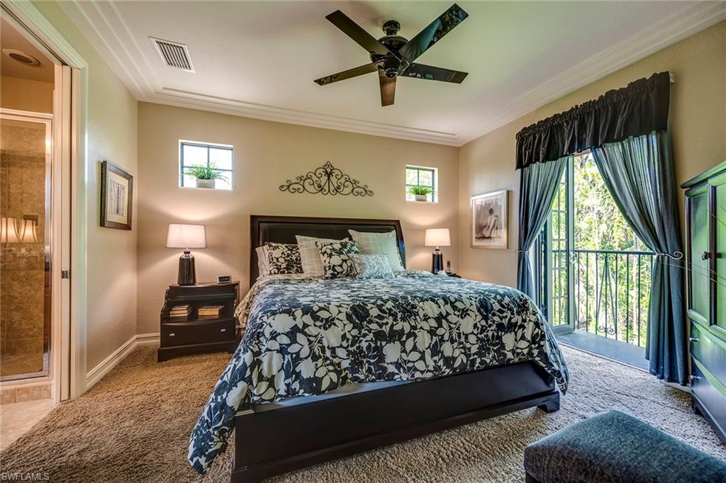 9161 Chula Vista Street, Unit 1352 Naples, FL 34113 - Photo 13 of 23 a bedroom with a large bed and a large window