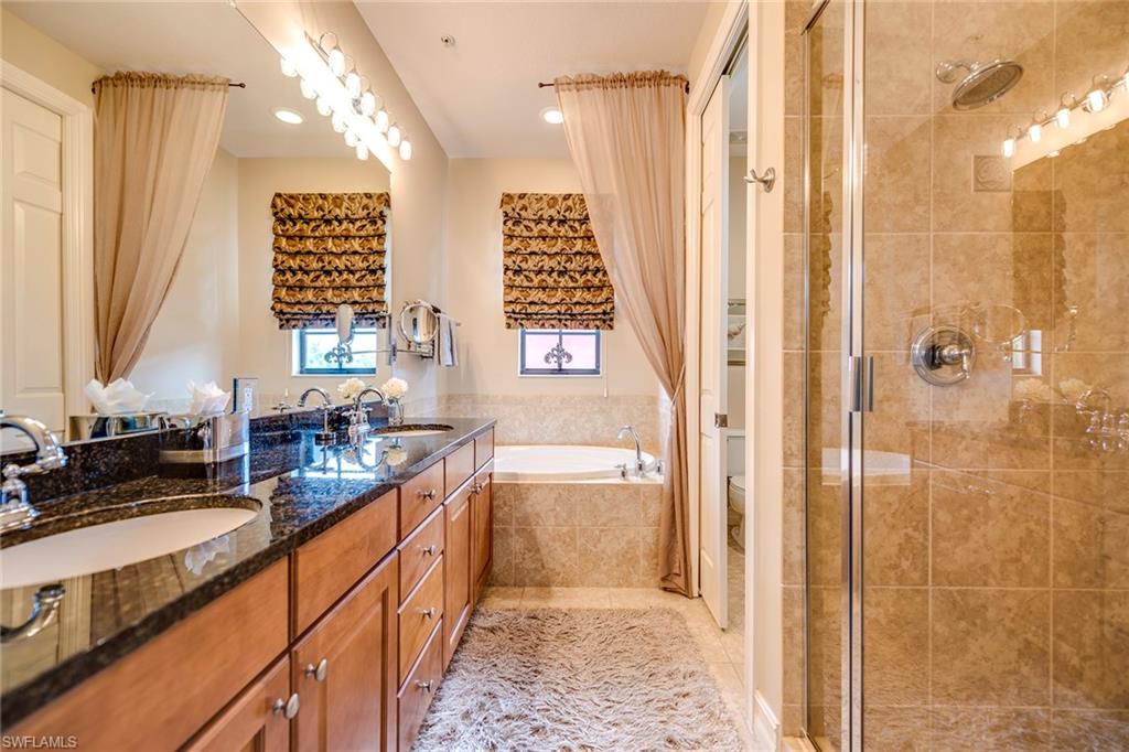 9161 Chula Vista Street, Unit 1352 Naples, FL 34113 - Photo 17 of 23 a bathroom with a double vanity sink a mirror and a shower