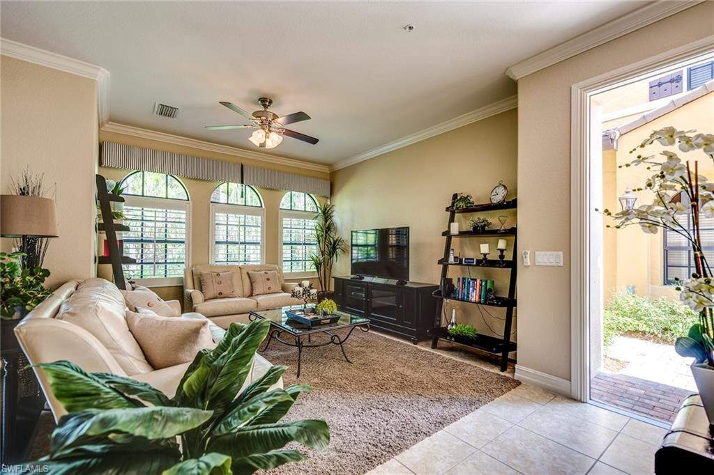 9161 Chula Vista Street, Unit 1352 Naples, FL 34113 - Photo 6 of 23 a living room with furniture and a large window
