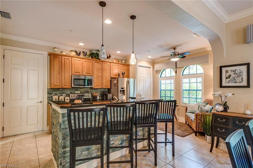 9161 Chula Vista Street, Unit 1352 Naples, FL 34113 - Photo 9 of 23 a view of a dining room and livingroom with furniture wooden floor a chandelier