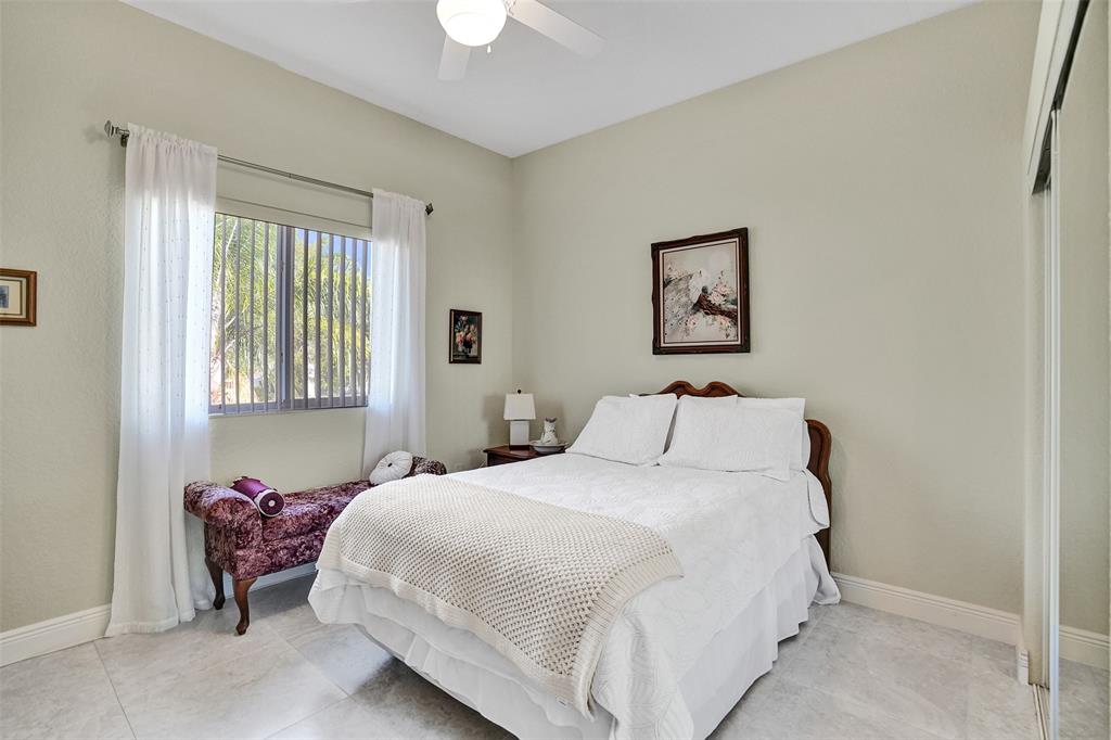 7967 Exeter Boulevard East, Unit 203 Tamarac, FL 33321 - Photo 21 of 42 a bedroom with a bed and a window