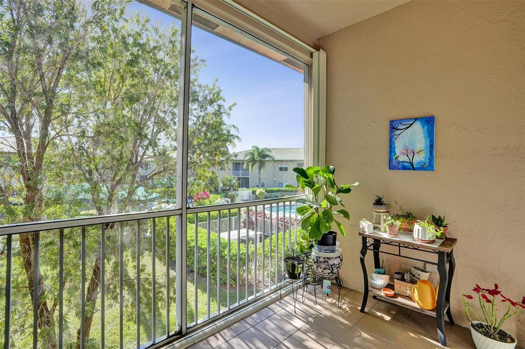 7967 Exeter Boulevard East, Unit 203 Tamarac, FL 33321 - Photo 28 of 42 a balcony with table and chairs