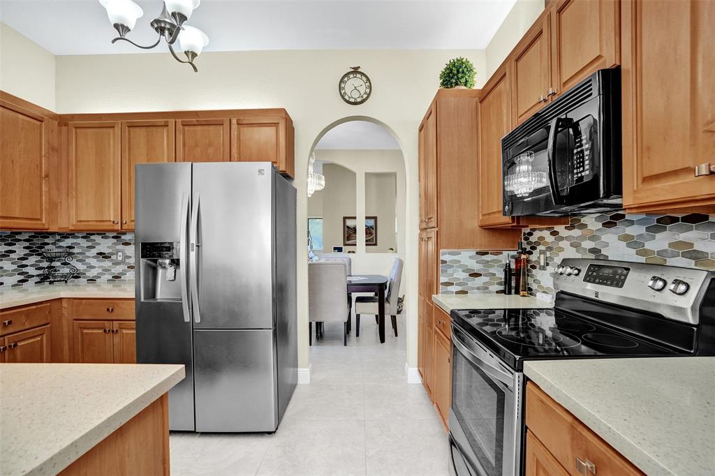 7967 Exeter Boulevard East, Unit 203 Tamarac, FL 33321 - Photo 4 of 42 a kitchen with stainless steel appliances granite countertop a refrigerator a stove and a sink