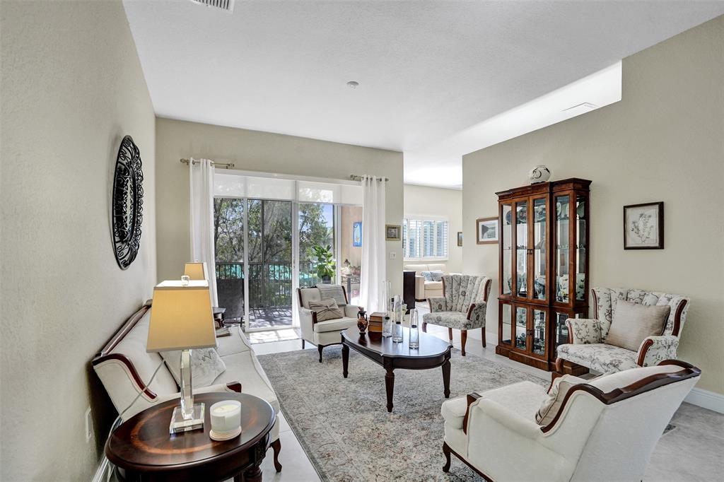 7967 Exeter Boulevard East, Unit 203 Tamarac, FL 33321 - Photo 7 of 42 a living room with furniture and a window