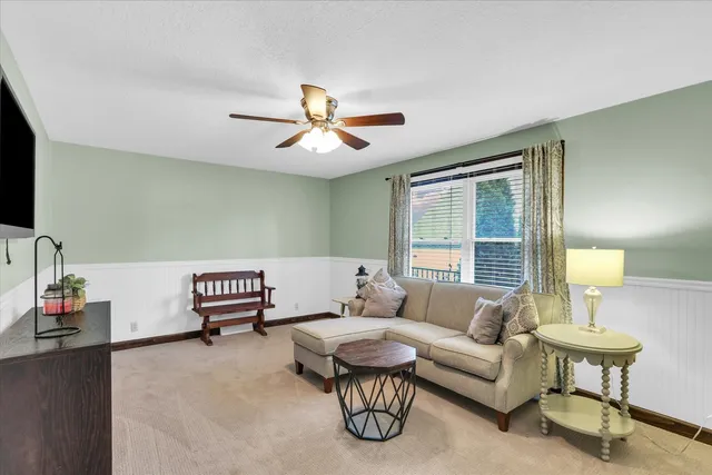 a living room with furniture a lamp and a flat screen tv
