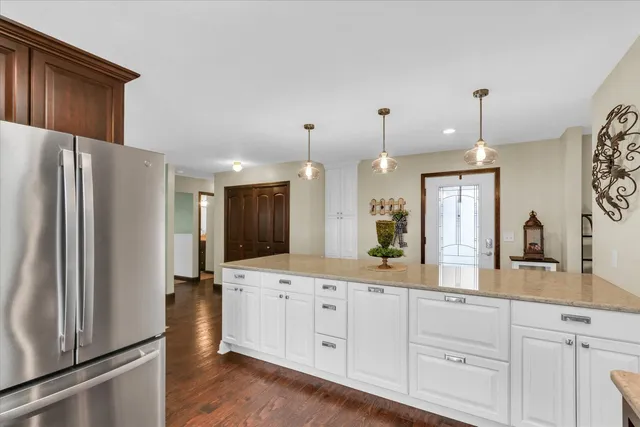 a large kitchen with a refrigerator a sink and cabinets