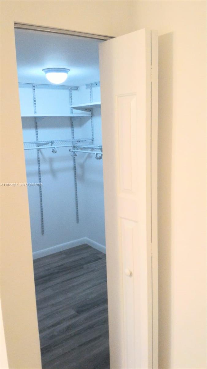 1755 Northeast 116th Road, Unit 15 North Miami, FL 33181 - Photo 4 of 9 a view of walk in closet with wooden floor