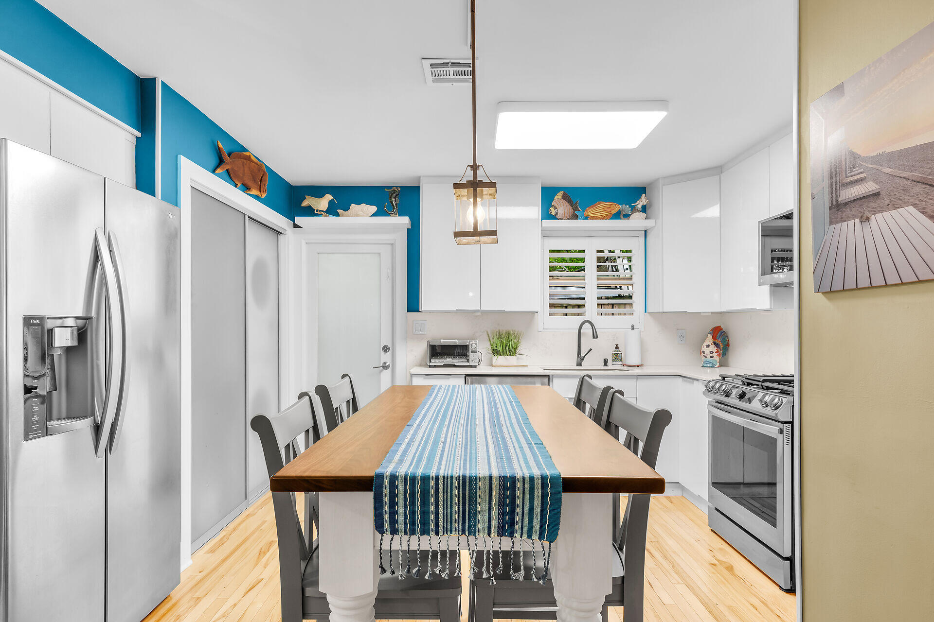 808 Virginia Street, Unit 4 Key West, FL 33040 - Photo 8 of 32 a kitchen with stainless steel appliances a table chairs and a refrigerator