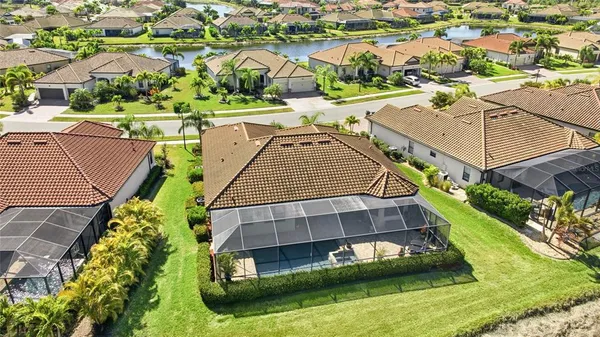 an aerial view of a house with a big yard and large trees