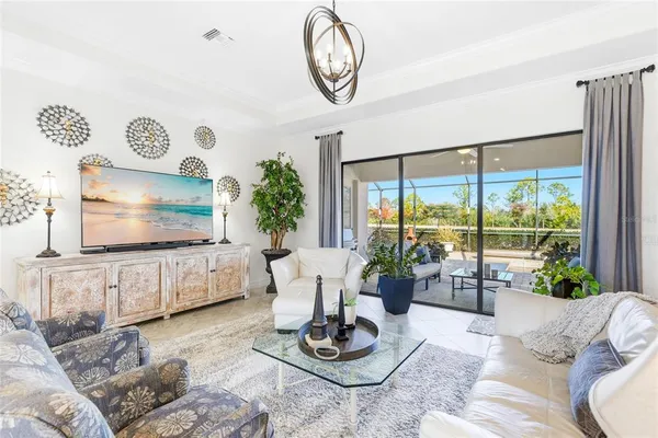 a living room with furniture a flat screen tv and a large window