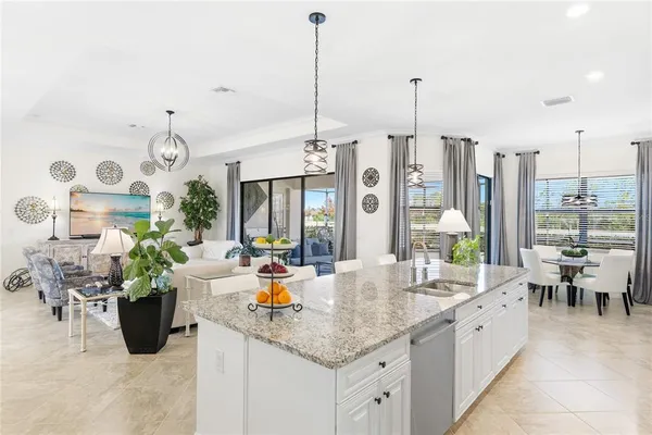 a large kitchen with sink a counter top space and living room view