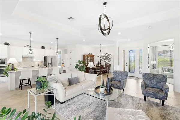 a living room with furniture kitchen and a chandelier