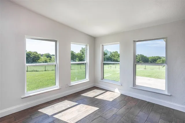 a view of an empty room with two windows and a room