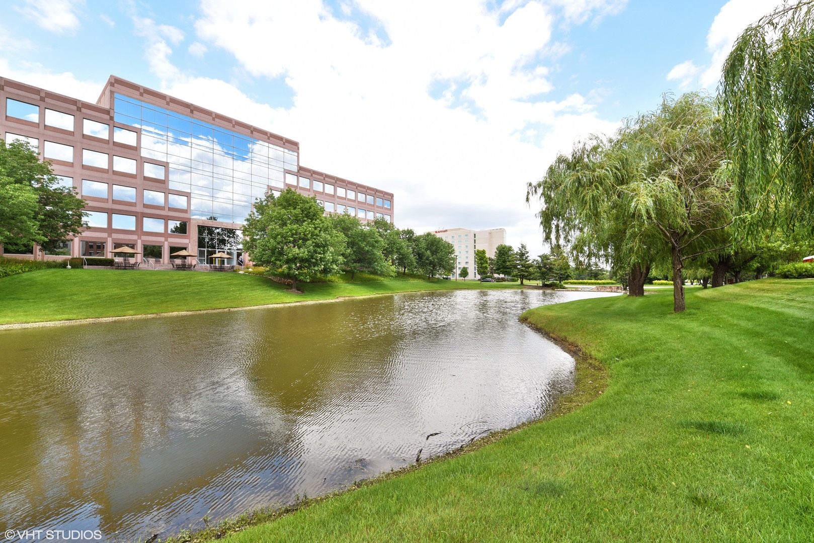 1000 Village Center Drive, Unit 312 Burr Ridge, IL 60527 - Photo 22 of 25 a view of a lake with a building and a big yard with plants and large trees