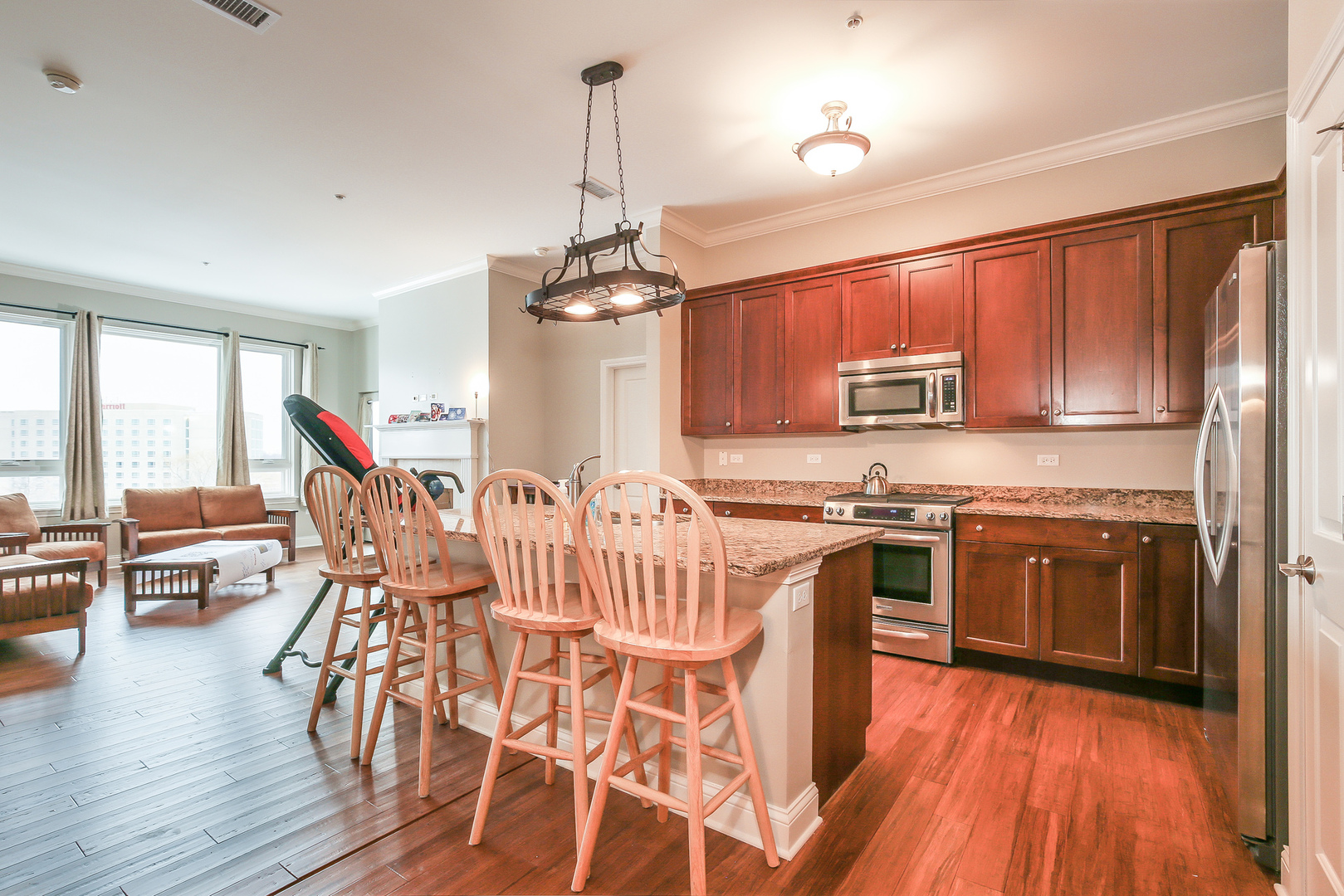 1000 Village Center Drive, Unit 312 Burr Ridge, IL 60527 - Photo 8 of 25 a open kitchen with stainless steel appliances granite countertop a stove top oven a sink dishwasher and wooden cabinets with wooden floor