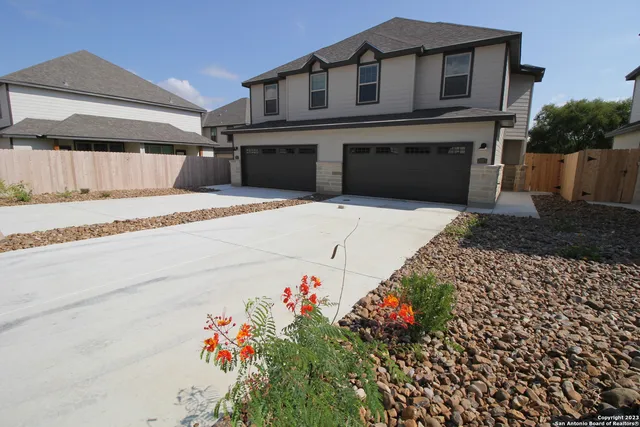 a front view of a house with a yard and a garage