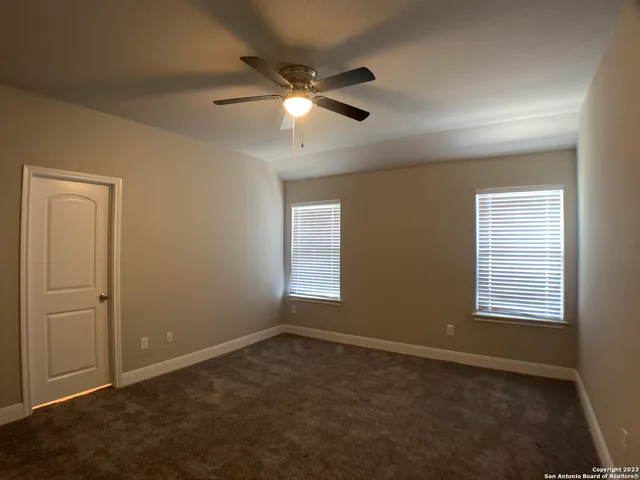 an empty room with windows and fan
