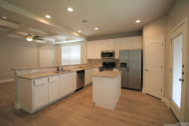 a kitchen with a refrigerator and a stove top oven