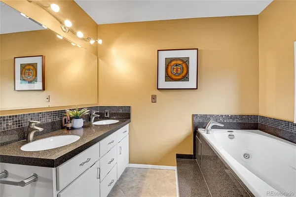 a bathroom with a tub sink and mirror