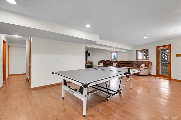 a living room with furniture pool table flat screen tv and couches