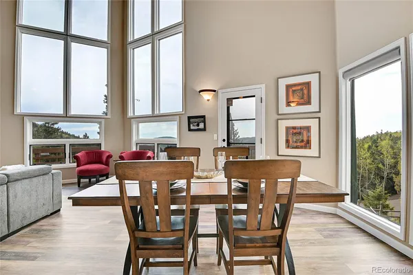 a view of a dining room with furniture large windows and wooden floor