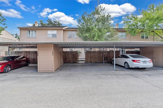 a couple of cars parked in front of a house
