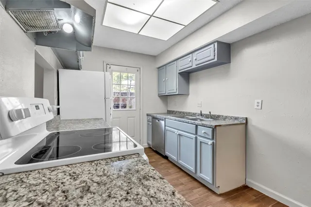 a kitchen with stainless steel appliances granite countertop a sink stove and cabinets