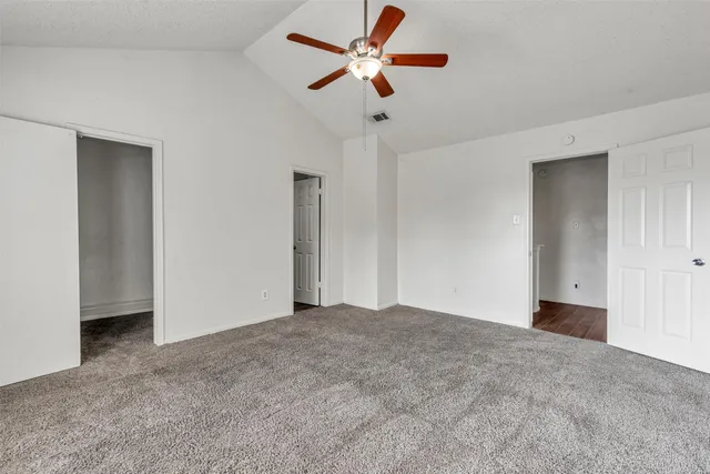 a view of an empty room with a ceiling fan