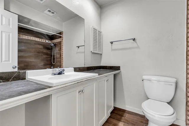 a bathroom with a toilet sink and mirror