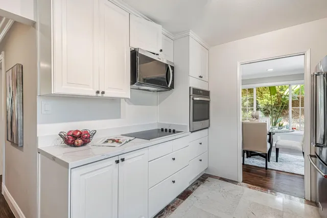 a kitchen with white cabinets and sink