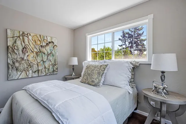 a bedroom with a bed and a painting on the wall